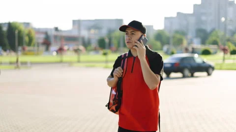 Food delivery guy with red backpack deliver orders. Male courier with isothermal Stock Footage 194599782