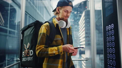 Food Delivery Man Riding Elevator Using Smartphone Stock Footage 167835578