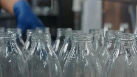 Food factory worker checking empty glass bottles on production line Stock Illustration