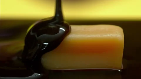Food footage: dark chocolate pour on caramel candy bar Stock Footage