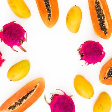 Food frame with papaya, mango and dragon fruits on white background. Flat lay Stock Photos