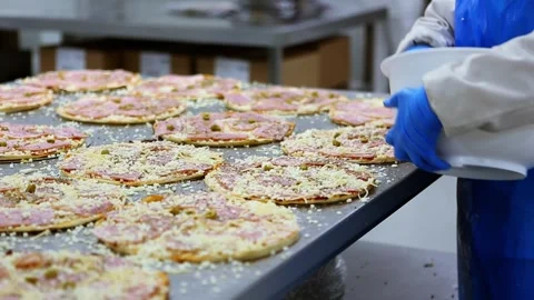Food industry worker preparing pizzas in a factory Stock Footage 302809255