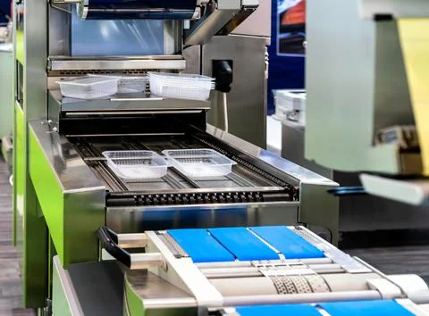 Food packaging machine with empty eco-friendly plastic containers on conveyor Foto stock