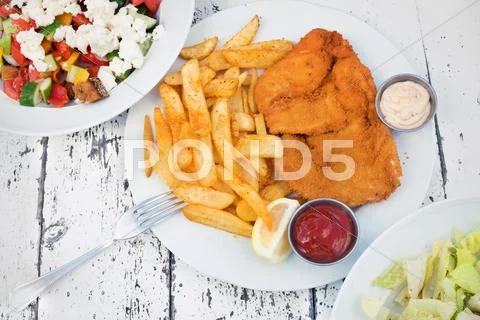 Food with potatoes, chicken schnitzel and salads Stock Photos