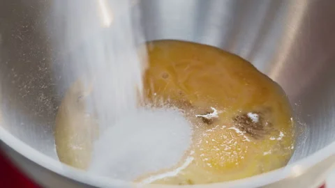 Food preparation. Adding sugar to raw eggs in a kitchen mixer. Stock Footage 302650416