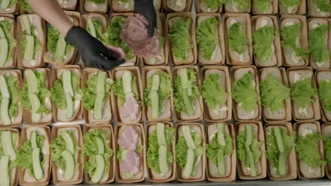 Food preparation process showing hands adding sliced ham to lettuce and Stock Footage 340172295