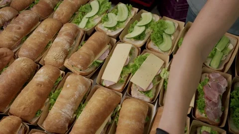 Food preparation process showing hands assembling sandwiches with lettuce Stock Footage 340172425