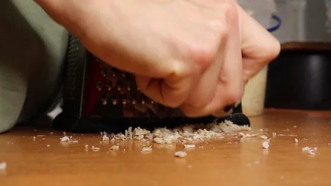 Food Preparation Using a Grater on the Kitchen Counter Surface for Delicious Stock Footage 296221806