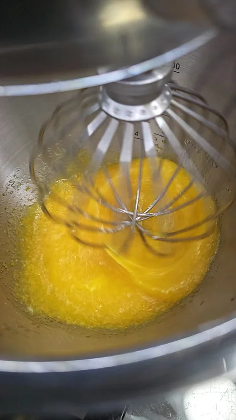 Food processor beat egg yolks, eggs and sugar in a metal bowl using an electric Stock Footage 275691347