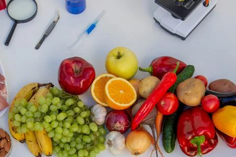Food Quality Testing: Microscope and Fresh Fruits and Vegetables Stock Photos