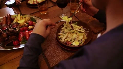The food in the restaurant. A man sits at a table and eats a salad with chicken Stock Footage 208632296