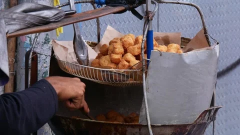 Food vendor preparing dish called tahu goreng cripsy or crispy fried tofu Stock Footage 246719380
