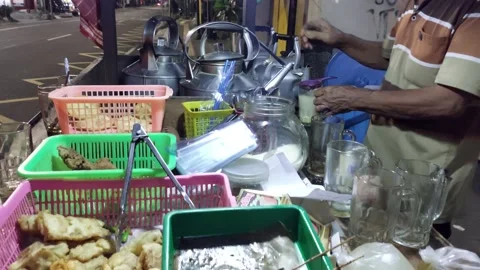 A food vendor is preparing drinks ordered by customers at night Stock Footage 236520215