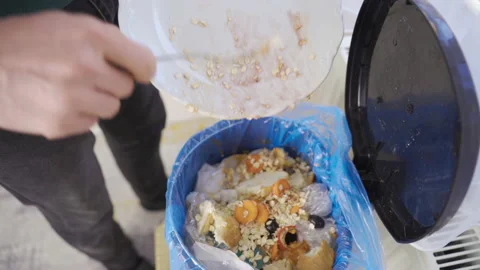 Food waste. When he throws food and grain in the trash, he consumes it wastefull Stock Footage 220592479