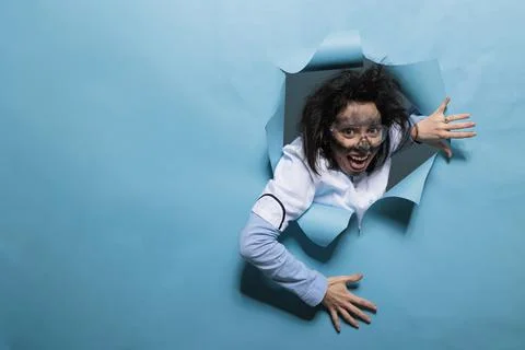 Foolish humorous scientist with comic expression on blue background Stock Photos