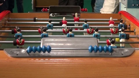 Foosball table during a match with people playing Stock Footage 71964994