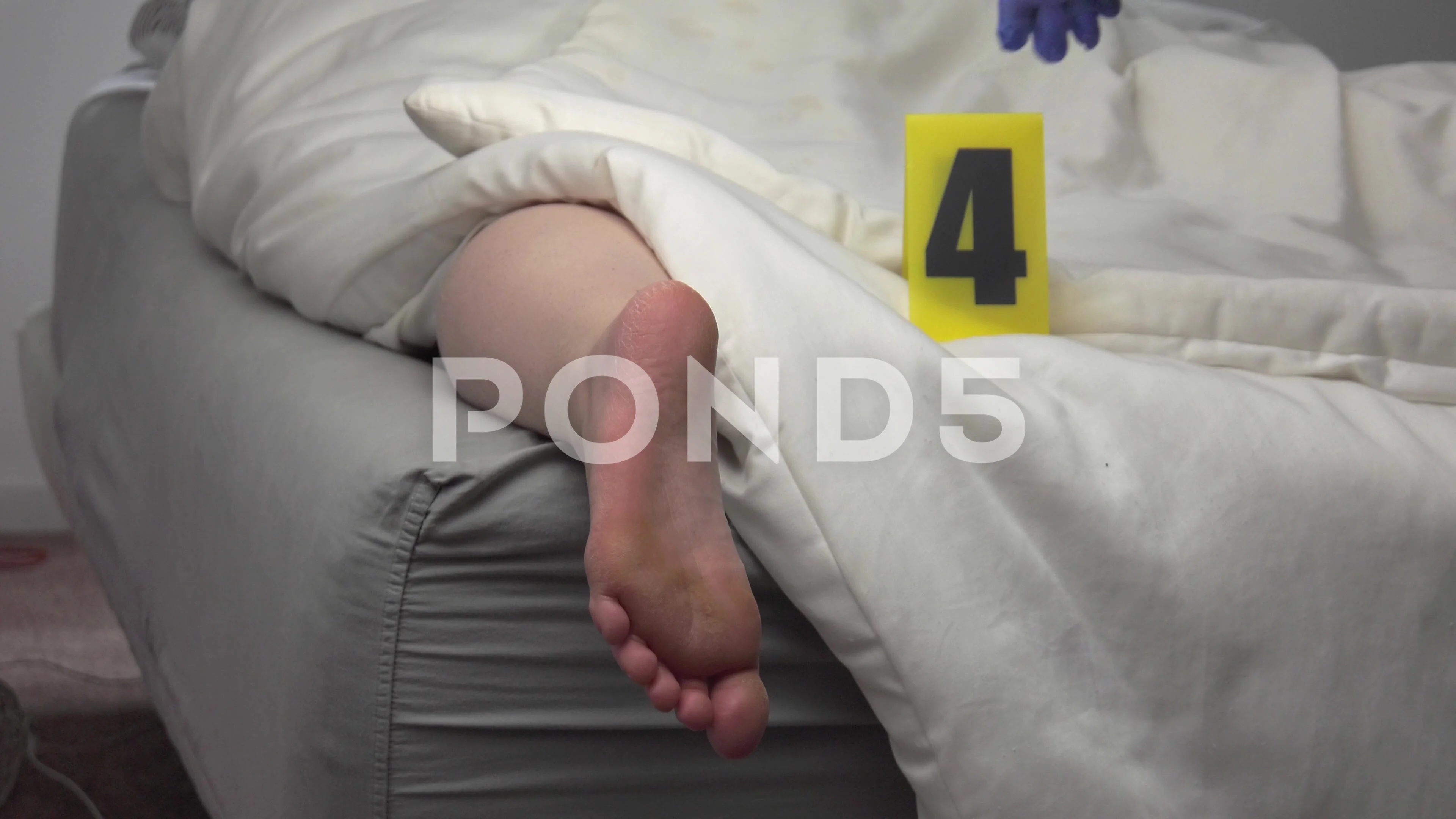 Foot of Dead Body of a Woman on a bed At A Crime Scene