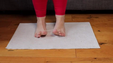 Foot exercise using resistance band looped around big toes to improve toe Stock Footage 317155769