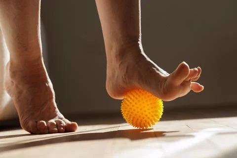 Foot Massage Exercise Using Spiky Ball for Myofascial Release at Home Stock Photos