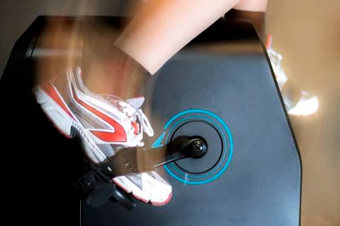 Foot moving while pedaling with the exercise bike Stock Photos