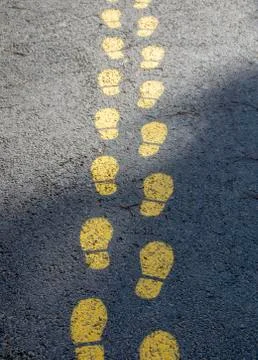 Foot pattern on asphalt, indicates the way Stock Photos