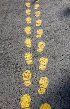 Foot pattern on asphalt, indicates the way Stock Photos