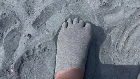 A foot playing in black sand Stock-Footage 240858159