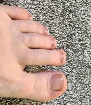 A foot is positioned on a soft, textured surface, displaying well-groomed Foto stock