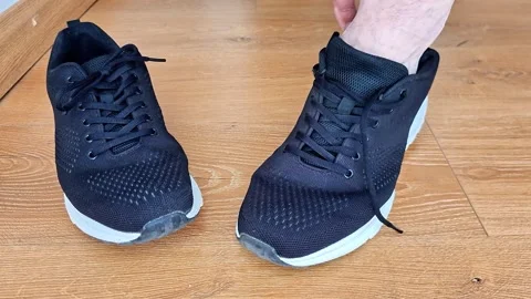 Foot Sliding Into Running Sneaker Close Up on Wooden Floor Indoors Vídeos de archivo 343067011