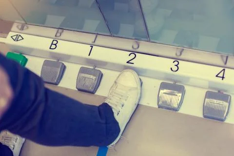 The foot is stepping on the foot switch to select the floor in the passenger  Stock Photos