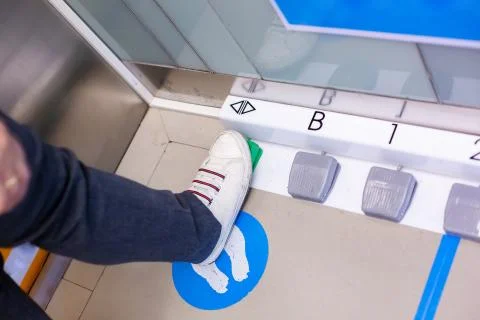 The foot is stepping on the foot switch to select the floor in the passenger  Stock Photos