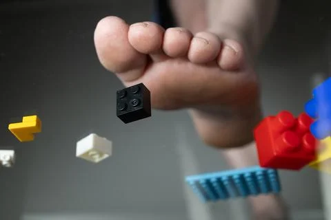 Foot Stepping on LEGO Bricks From a Construction Kit in a Playful Environment Stock Photos