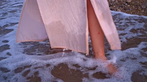 Foot steps in shallow water on a beach during sunset in warm weather Stock Footage 342787138