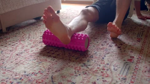 Foot therapy routine, Gentle rolling of foam roller on foot Stock Footage 320958561