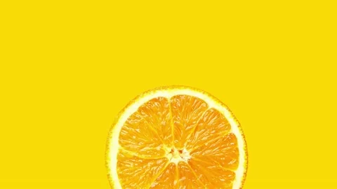 Footage animation of spinning rotating slice of ripe juicy orange on yellow Stock Footage 135273901