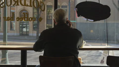 Footage From Behind of a Man Talking on a Cell Phone at a Coffee Shop Stock Footage 208744614