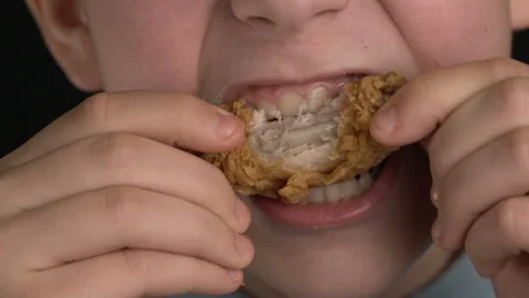 Footage boy eats chicken wings or nuggets, fast food Stock Footage 102461696