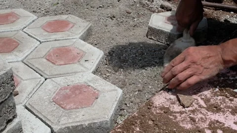 Footage of a brown-skinned man's hands installing a paving block floor Stock Footage 303326929