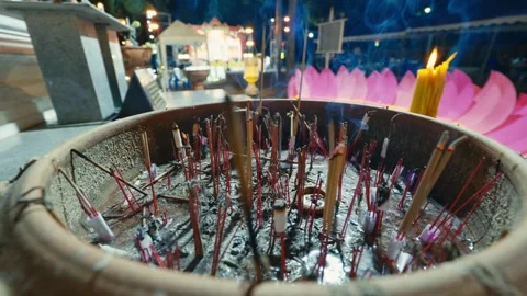 Footage of diffuser incense sticks burning in a pot at a temple during the Loy Video stock 321383371