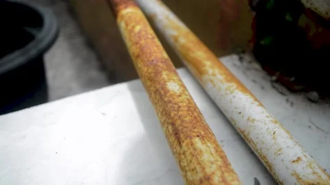 Footage displays a close up of two white metal pipes with rust on a tiled s.. Stock Footage 320995922