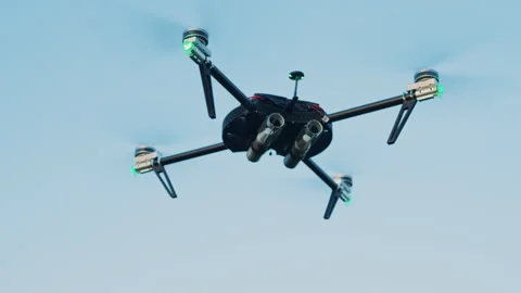 Footage of drone on background of blue sky. Scouting and surveillance concept Video stock 241007348