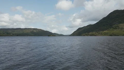 A footage from a drone quickly hovering over a lake surrounded by high hills. Stock Footage 248620698