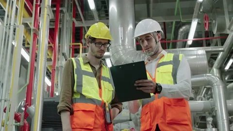 Footage of engineer and Foreman are discussing the plant layout on the blueprint Stock Footage 154875533