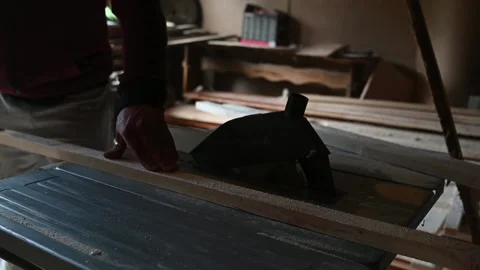Footage of a male using a flatbed sander machine to polish a wood plank in his Stock Footage 131056100