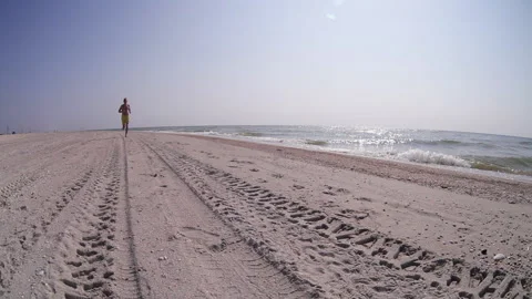 Footage man approaching camera running by sandy beach on sunny day Video stock 157921171
