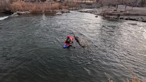 Footage of a man in a kayak sailing down the Truckee River at sunset in Reno Stock Footage 297008167