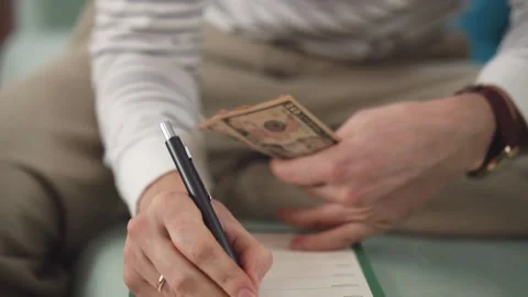 Footage of man sits while counts dollar money at table. Male hands holding .. Stock Footage 266469782
