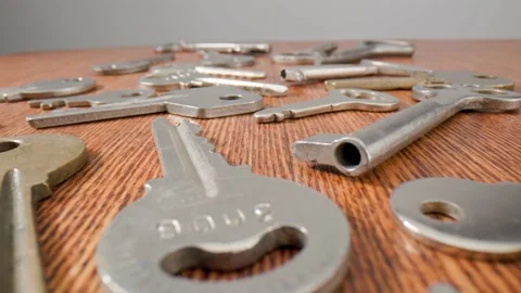 Footage movement over the keys lying on a old wooden background. Stock Footage 211396879