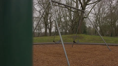 Footage Peaking Around a Play Structure of an Empty Swing Set Moving Stock Footage 208763768