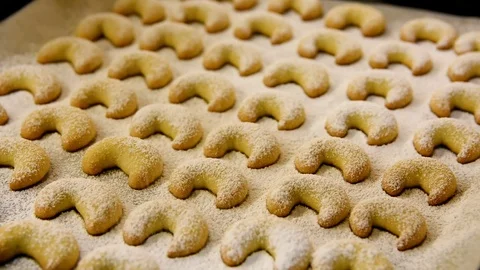 Footage of process of powdering with icing sugar home baked cookies crescents Stock Footage 99652290